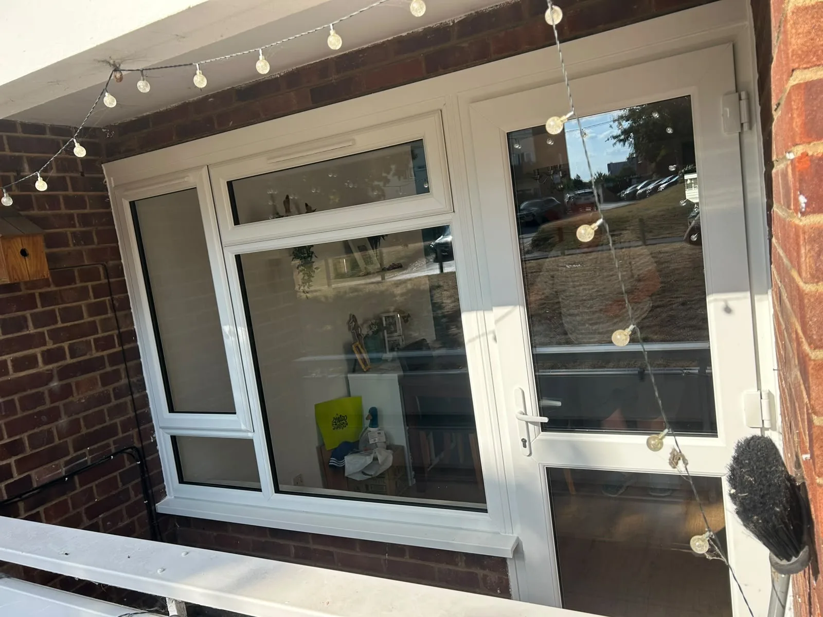 New white uPVC window and back door from outside, set in a red brick wall