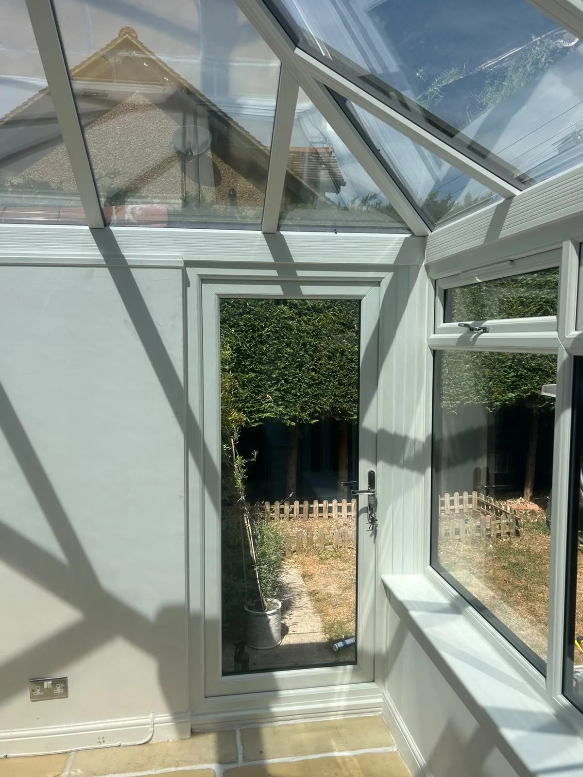Detail where the conservatory frame meets the existing brick wall